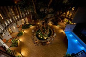 an overhead view of a courtyard with a tree and chairs at Red Door Samsen Hotel, Bangkok in Bangkok