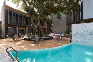 a courtyard with a table and chairs and a pool at Red Door Samsen Hotel, Bangkok in Bangkok