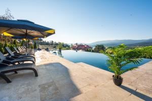 a group of chairs and an umbrella next to a pool at Katalina Resort in Tsigov Chark