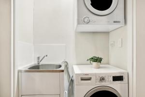 シドニーにある8 mins from Sydney Airport! 1BR with Courtyardのシンクと洗濯機付きのキッチン