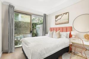 シドニーにある8 mins from Sydney Airport! 1BR with Courtyardの大きなベッドと大きな窓のある寝室