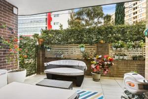シドニーにある8 mins from Sydney Airport! 1BR with Courtyardのパティオ(ベンチ、鉢植えの植物付)