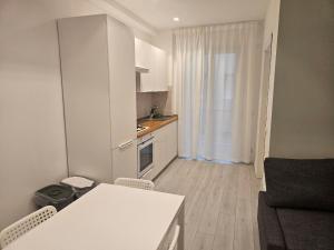 a small white kitchen with a table and chairs at MiPA in Milazzo