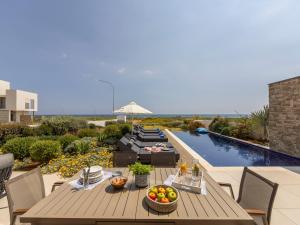 a patio with a table and chairs and a pool at Villa Pliades in Ayia Napa