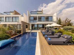 a villa with a swimming pool in front of a house at Villa Pliades in Ayia Napa