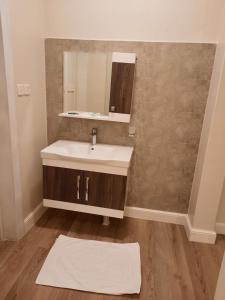 un baño con lavabo y espejo en دار داكن للشقق المخدومة اقتصادي, en Riad