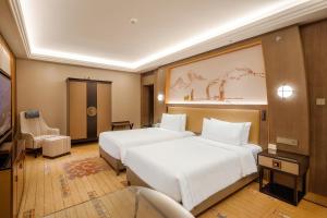 a hotel room with two beds and a chair at Chengdu Tibetan Hotel in Chengdu +73 photos