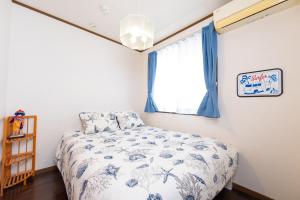 a bedroom with a bed and a window at Hoshitabi Villa Sumuide in Nago