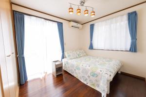 a bedroom with a bed and two large windows at Hoshitabi Villa Sumuide in Nago +83 photos
