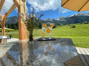 a table with two glasses and an umbrella on a patio at Chalet Inarpa - Appartements et Suites in La Clusaz