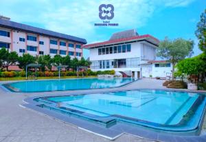 任抹Bandung Permai Hotel Jember的建筑物前的一个大型游泳池