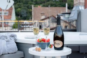 a bottle of champagne and two glasses on a table at KERAMIK Suites in Merano