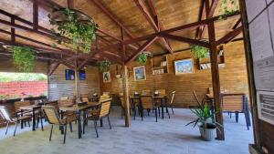 a restaurant with wooden walls and tables and chairs at Casa Tatiana Eforie Nord in Eforie Nord