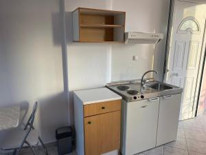 a small kitchen with a sink and a stove at Pefki Apartment 1 in Artemísion