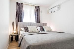 ein Schlafzimmer mit einem großen Bett mit Fenster in der Unterkunft Apartman Brodarica Sibenik in Brodarica
