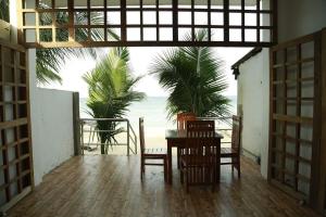 a dining room with a table and chairs and the beach at Blue Ocean Hotel in Trincomalee