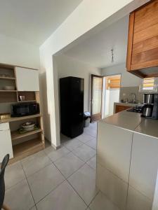- une cuisine avec un réfrigérateur noir dans la chambre dans l'établissement La villa Cannelle maison 1, à L'Étang-Salé