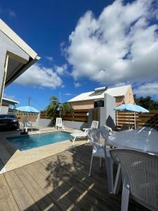 a patio with a table and chairs next to a pool at La villa Cannelle maison 1 in Étang-Salé