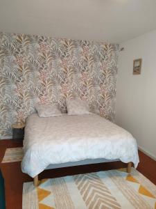 Bett in einem Zimmer mit einer Wand in der Unterkunft Jolie maison in Vaas