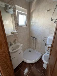 a small bathroom with a toilet and a sink at SNG Apartmani in Brca