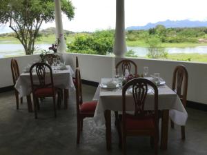 une salle à manger avec tables et chaises avec vue sur une rivière dans l'établissement Aligama Cottage, à Talakolawela 8 autres photos