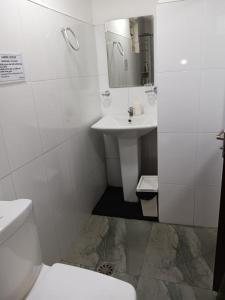 une salle de bain blanche avec un lavabo et des toilettes dans l'établissement Aligama Cottage, à Talakolawela