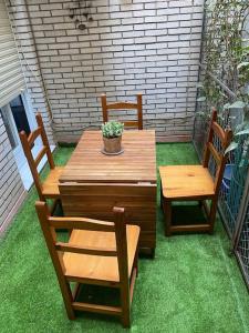 a wooden table and chairs on a patio with grass at Apartamento vacacional playa in Almería
