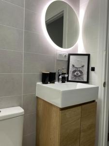 a bathroom with a white sink and a mirror at Apartamento vacacional playa in Almería +21 photos