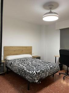 a room with a bed and a desk and a lamp at Apartamento vacacional playa in Almería