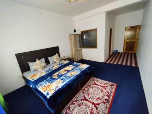a bedroom with a bed with a blue comforter at Nubra Holiday in Deskit