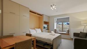 a bedroom with a bed and a desk and a table at Chalet Hotham 8 in Mount Hotham