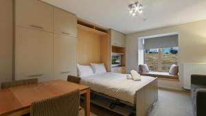 a bedroom with a bed and a desk and a table at Chalet Hotham 8 in Mount Hotham