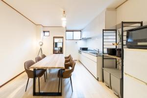a kitchen and dining room with a wooden table and chairs at 一棟貸切 Kuromon 3BedsRoom Doutonbori in Osaka