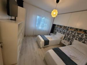 Una habitación de hotel con dos camas y un televisor. en Al Mare Apartments - 39, en Constanţa