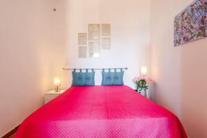 a bright pink bed in a white room with two lamps at The old man and the sea in Marina di Palma