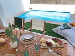 a table with food on it next to a swimming pool at RosaritoHomes in Madrigal de la Vera