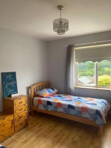 a bedroom with a bed and a dresser and a window at Macroom Spacious cosy 3 bedroom home in Cork