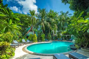 une piscine dans un complexe hôtelier avec des palmiers dans l'établissement Phuket Meet Holiday Hotel-Rawai 普吉岛相遇花园度假酒店-拉威店, à Rawai Beach 175 autres photos