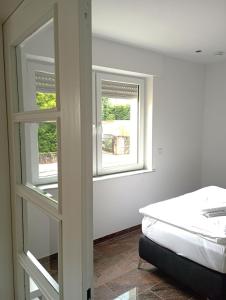 ein Schlafzimmer mit einem Bett und zwei Fenstern in der Unterkunft Monteurwohnungen Distelfeld in Saarbrücken