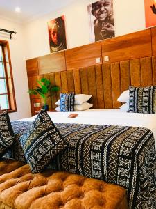 a bedroom with a large bed with a wooden headboard at Kerama Silent Lodge in Arusha +66 photos