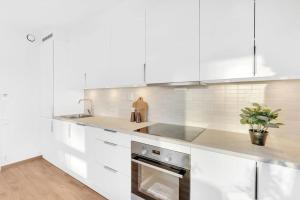 a white kitchen with a sink and a stove at Central Apartment in Bodø with ocean view in Bodø