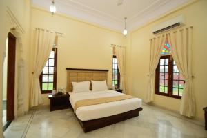 a bedroom with a bed and two windows at Aaram Baagh Agra by Pachar Group in Agra +32 photos