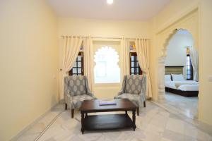 a living room with two chairs and a coffee table at Aaram Baagh Agra by Pachar Group in Agra