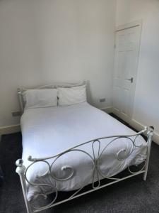 a bedroom with a white bed with a metal frame at Accessible Norton road in Stockton-on-Tees