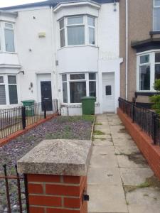 an empty sidewalk in front of a white house at Accessible Norton road in Stockton-on-Tees