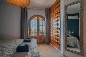 a bedroom with a mirror and a bed and a window at Casa Coromandel in Calpe +66 photos