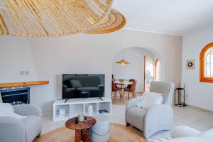 a living room with a tv and a couch and chairs at Casa Coromandel in Calpe
