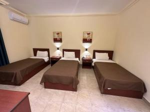 Giường trong phòng chung tại Rumman Hotel
