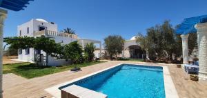 a villa with a swimming pool and a house at Villa Temlel in Temlale