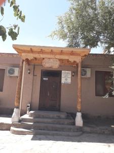 un edificio con porta in legno e scale di fronte di Hotel Allanazar Ota a Khiva